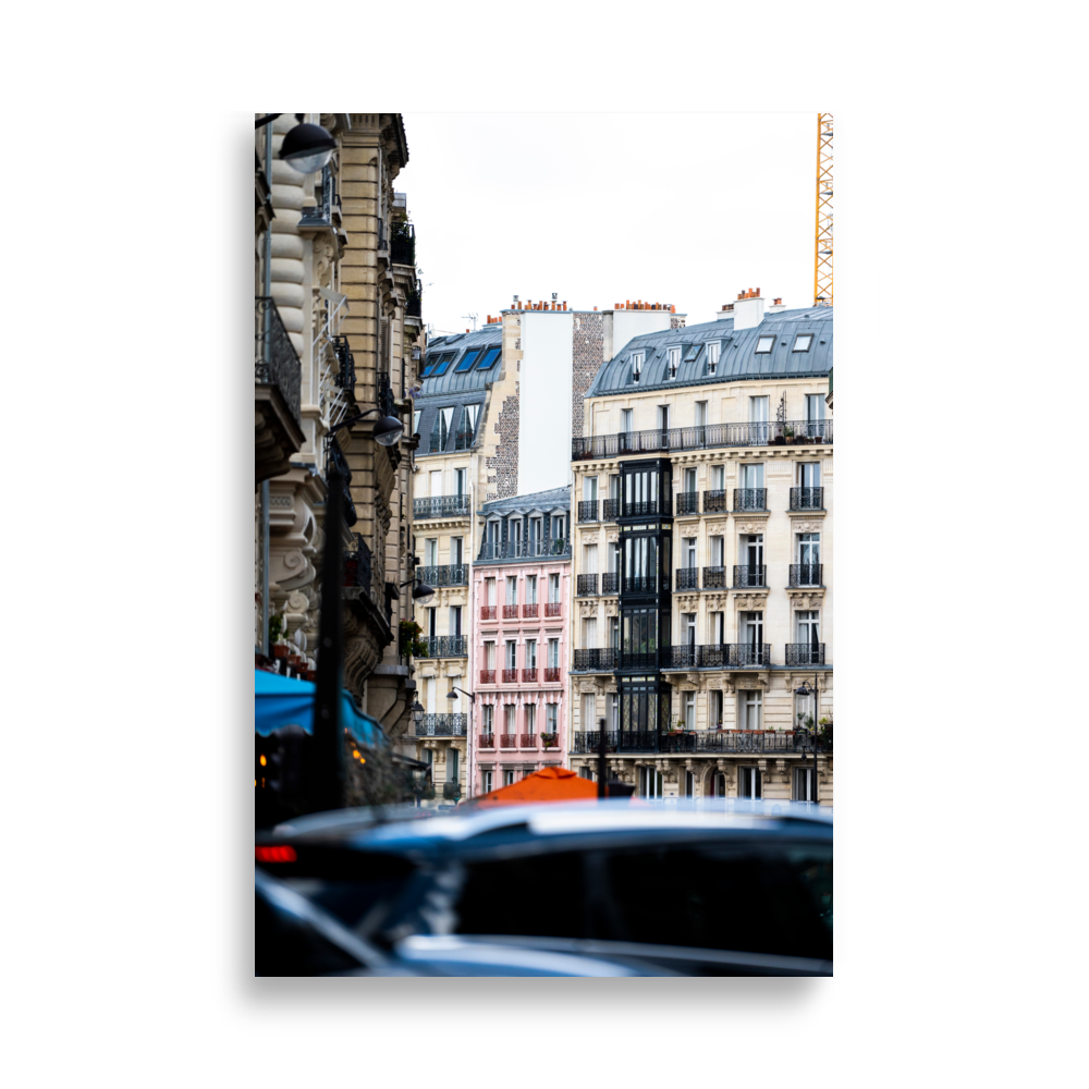 Petit bâtiment rose entre les grandes constructions à Paris.