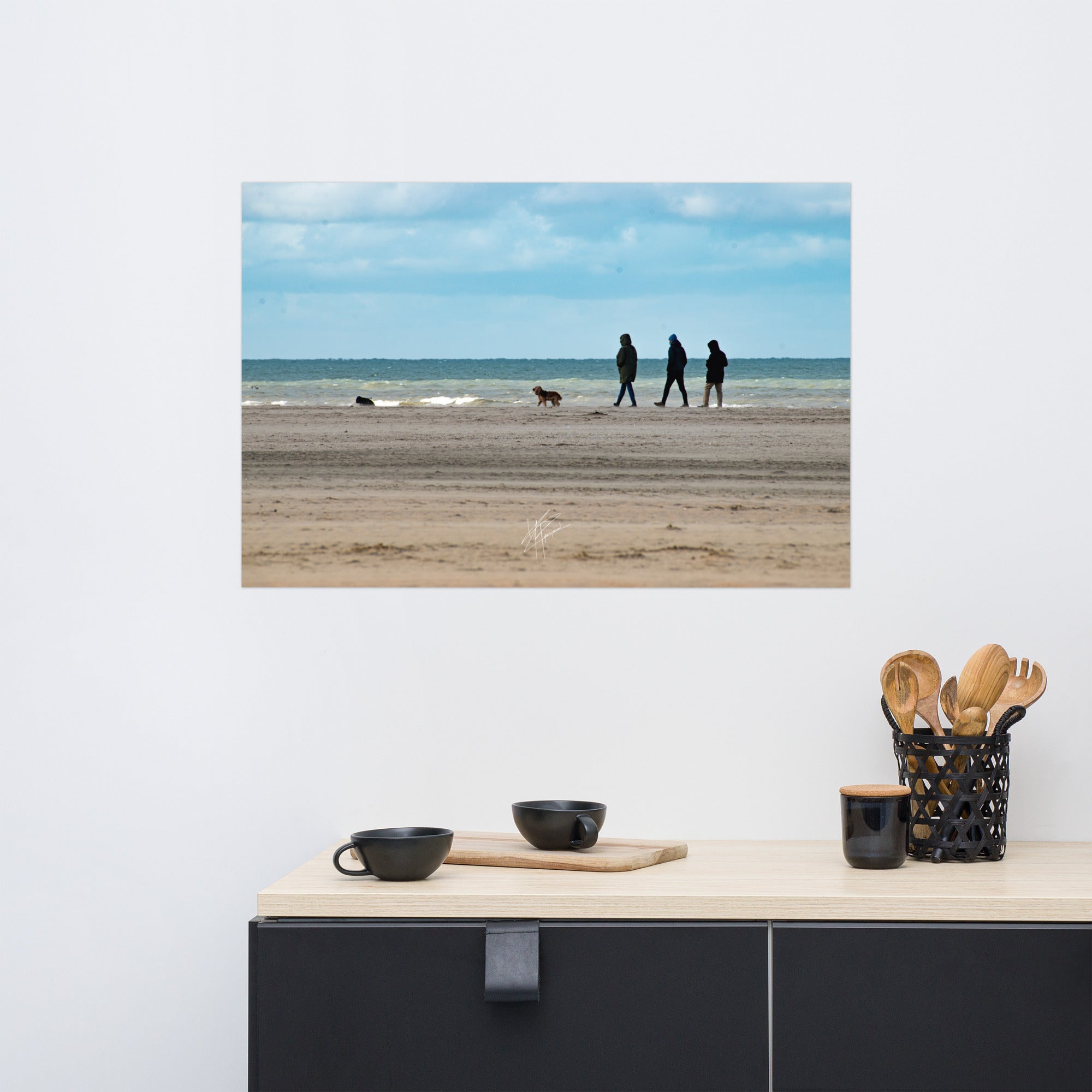 Photographie de la plage de Deauville avec des promeneurs et leur chien, capturant l'atmosphère tranquille et l'immensité de la mer normande.