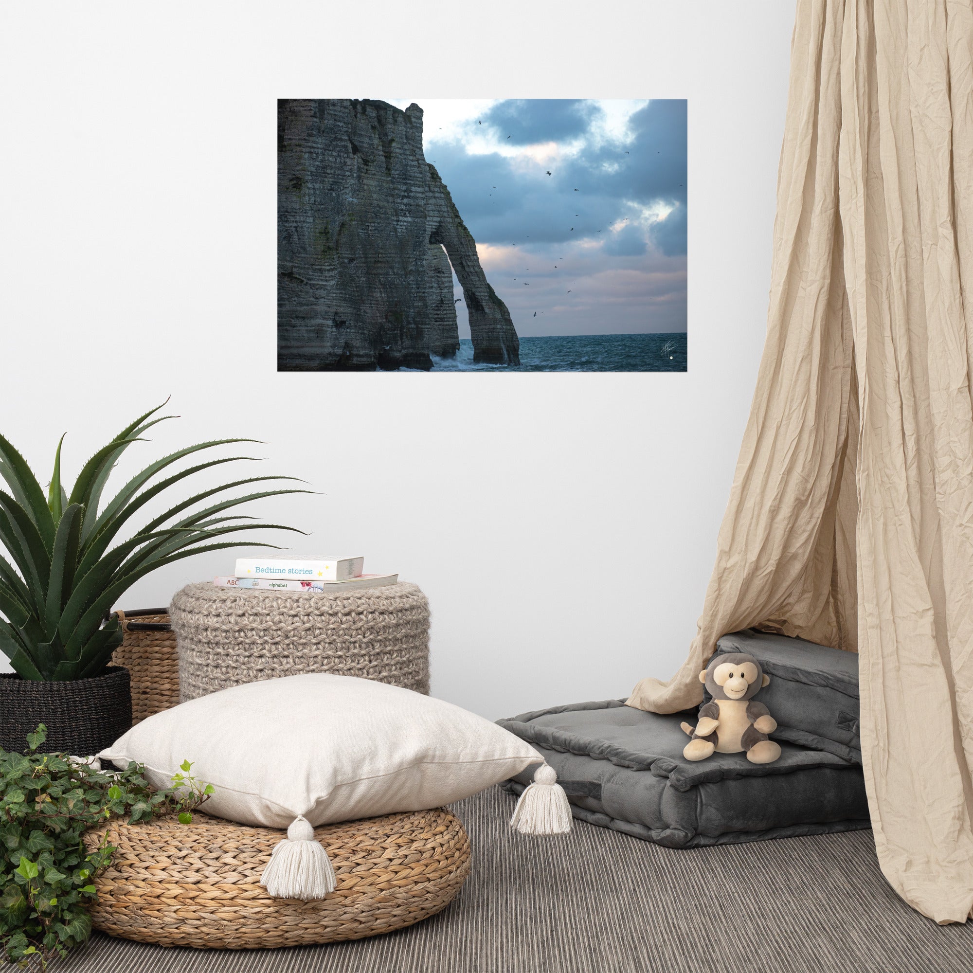 Vue panoramique des falaises d'Étretat avec des vagues s'écrasant puissamment sur la côte, sous un ciel nuageux où les mouettes virevoltent, incarnant la beauté sauvage de la Normandie.