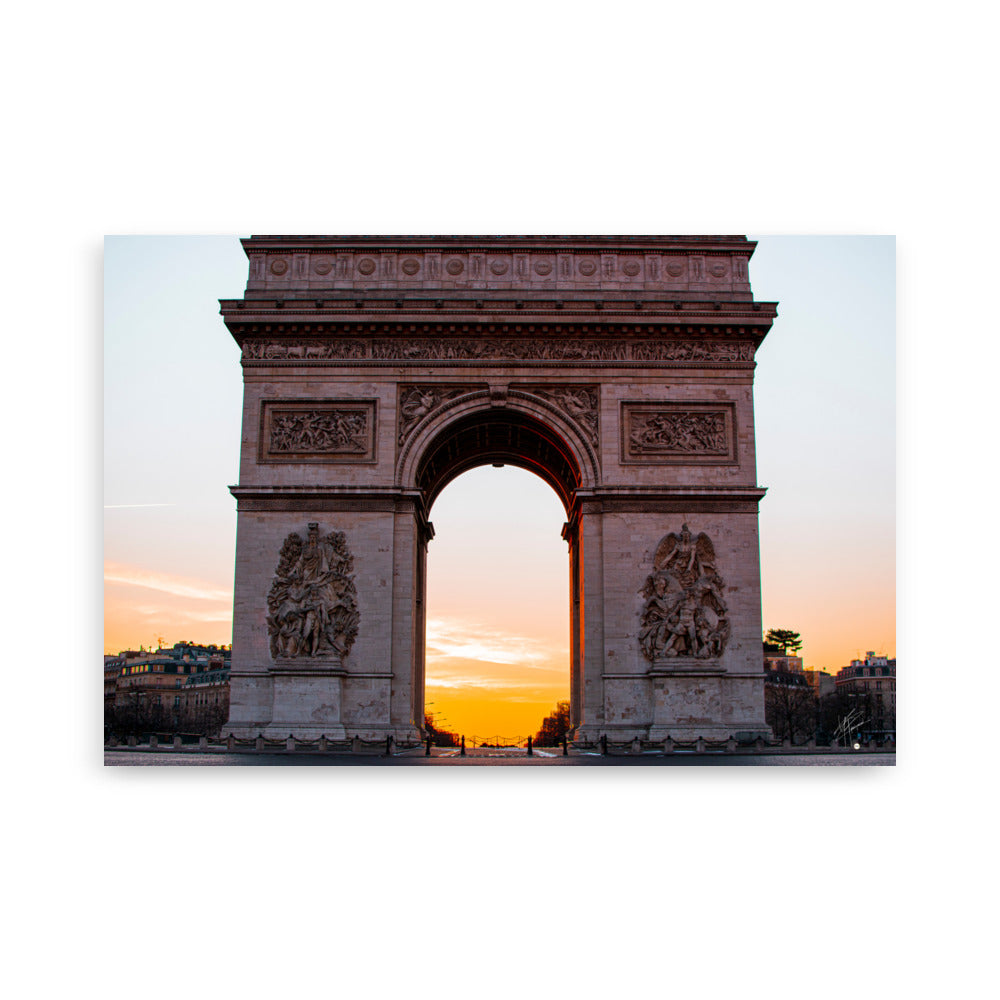 L'Arc de Triomphe de Paris au lever du soleil, ses contours majestueux se découpant contre un ciel orangé, symbolisant la gloire et l'espoir d'une nouvelle journée.