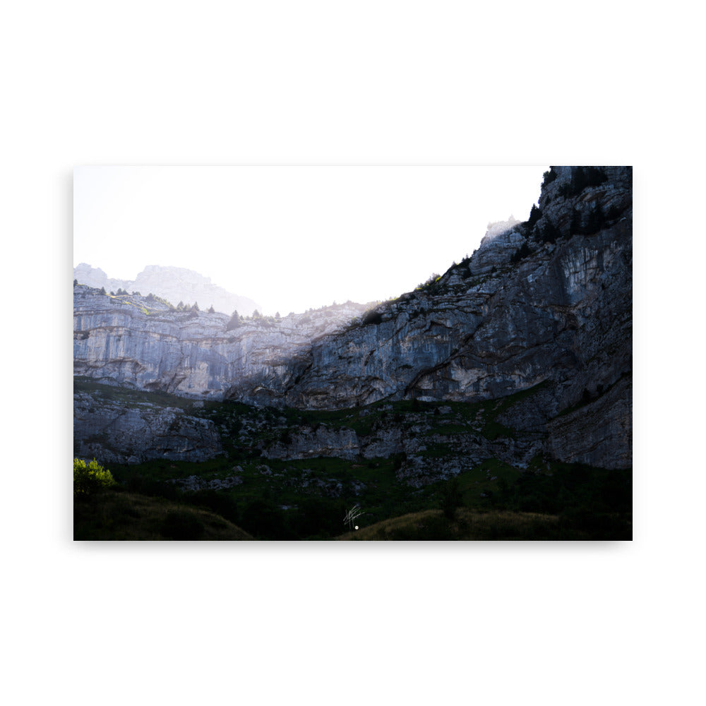 Photographie saisissante du Massif de la Tournette, capturant le moment où les premiers rayons du soleil éclairent la partie supérieure de la montagne et où l'ombre reste en bas.