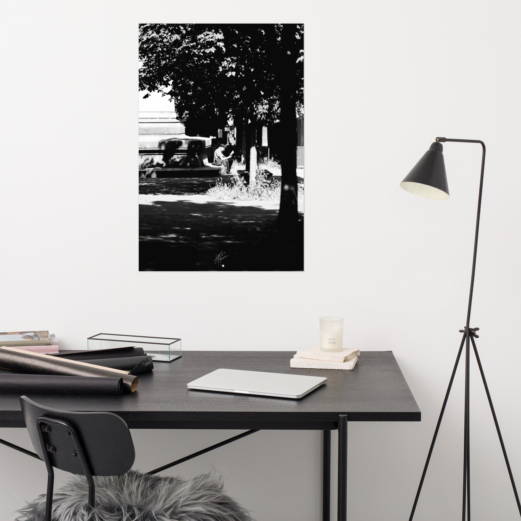 Poster photographique 'L'heure de lire', capturant un homme lisant un livre à Paris, en noir et blanc.