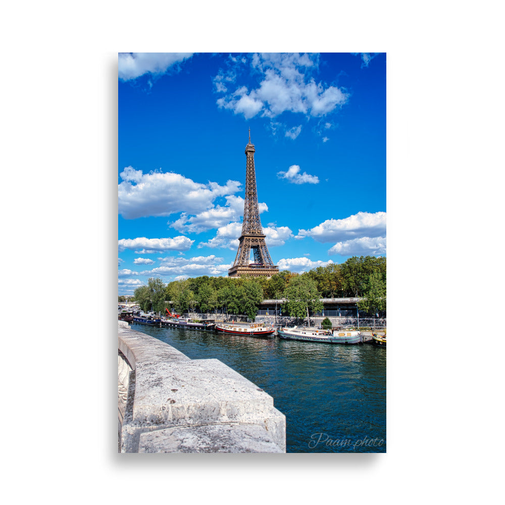 Vue panoramique de la Tour Eiffel et des péniches sur la Seine, sous un ciel bleu nuageux – une œuvre signée Antony Porlier.