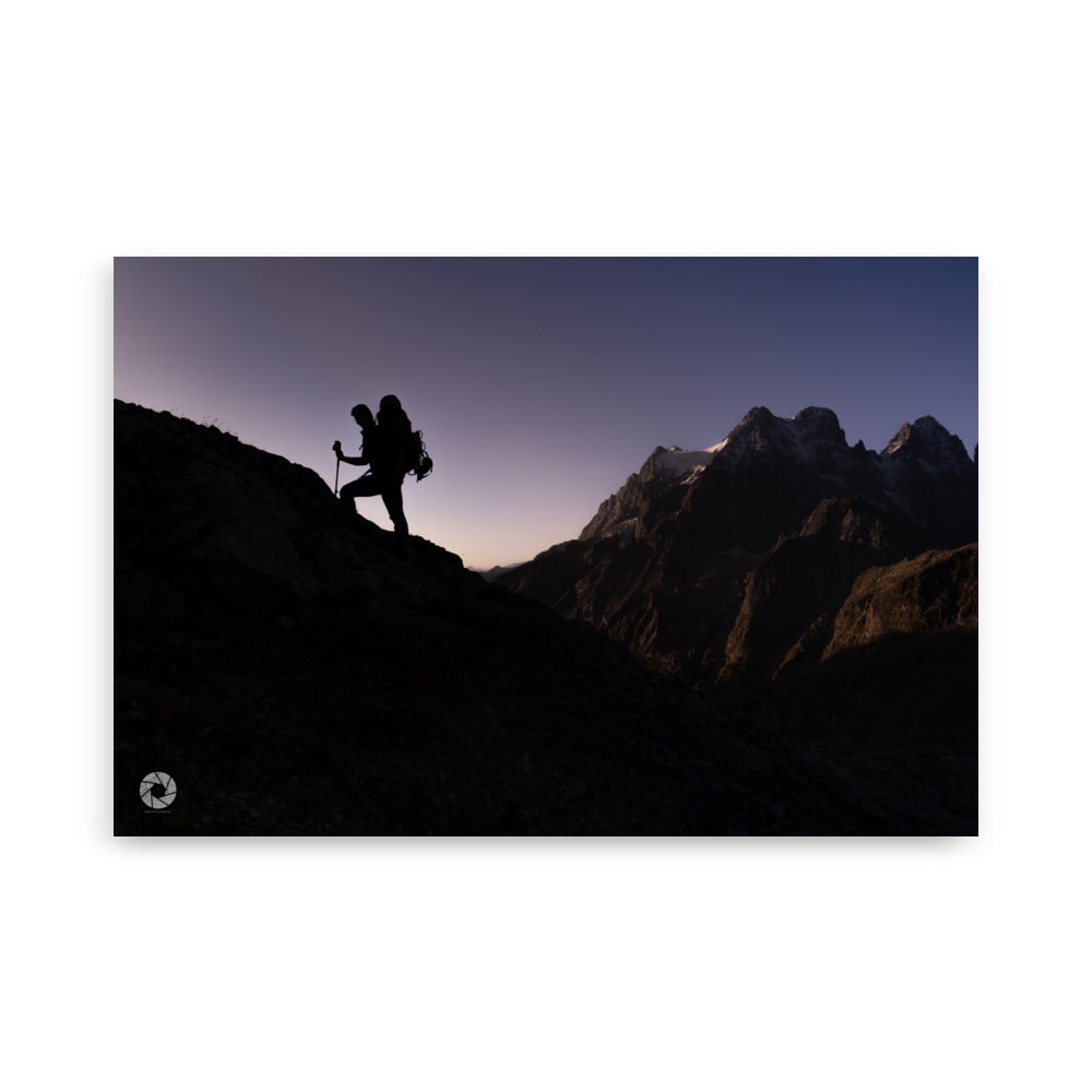 Photographie d'un randonneur progressant sur une montagne au crépuscule, capturée par Brad Explographie, illustrant la beauté et le défi de l'ascension dans un décor montagneux impressionnant.