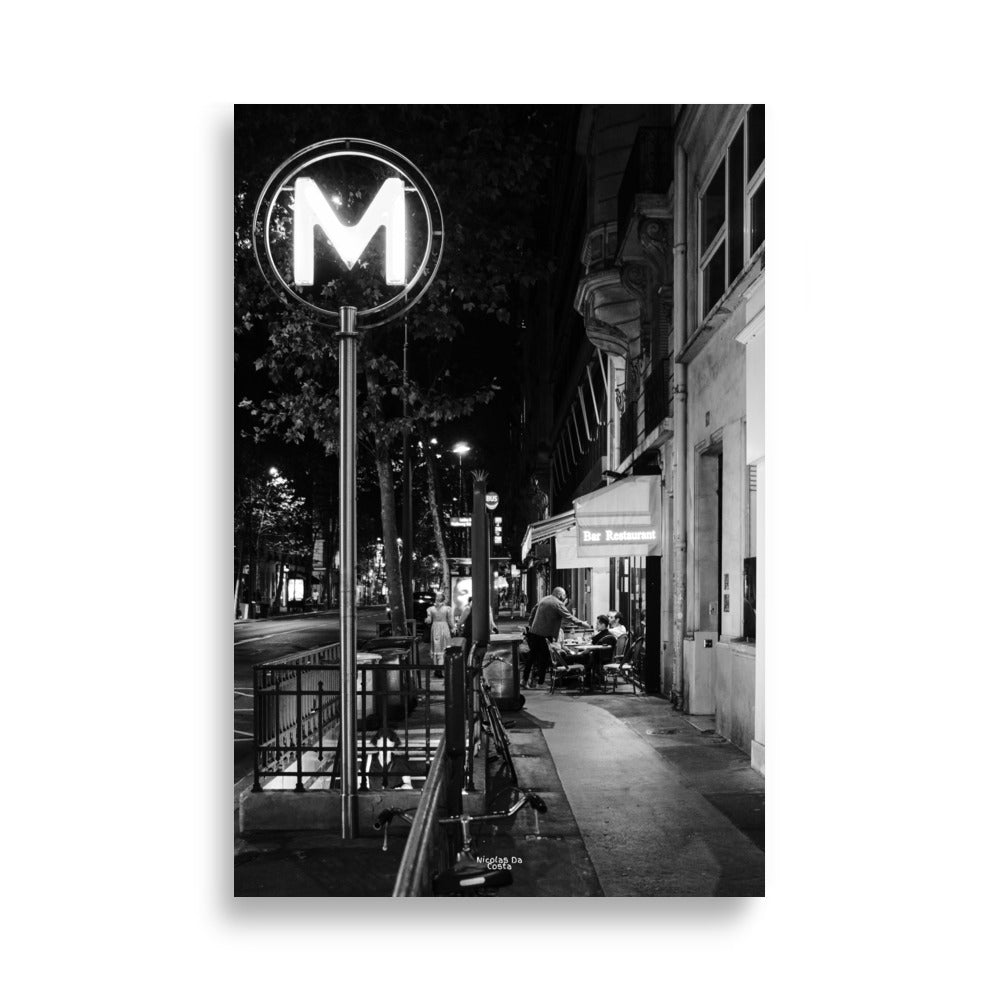 Photographie de rue en noir et blanc de "Rendez-vous Nocturne", capturant une scène de terrasse de café nocturne.