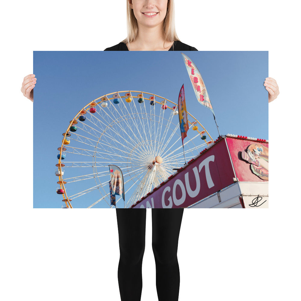 Photographie 'Jour de foire' montrant une grande roue et un kiosque de kebab sous un ciel bleu clair, capturée par Ilan Shoham.