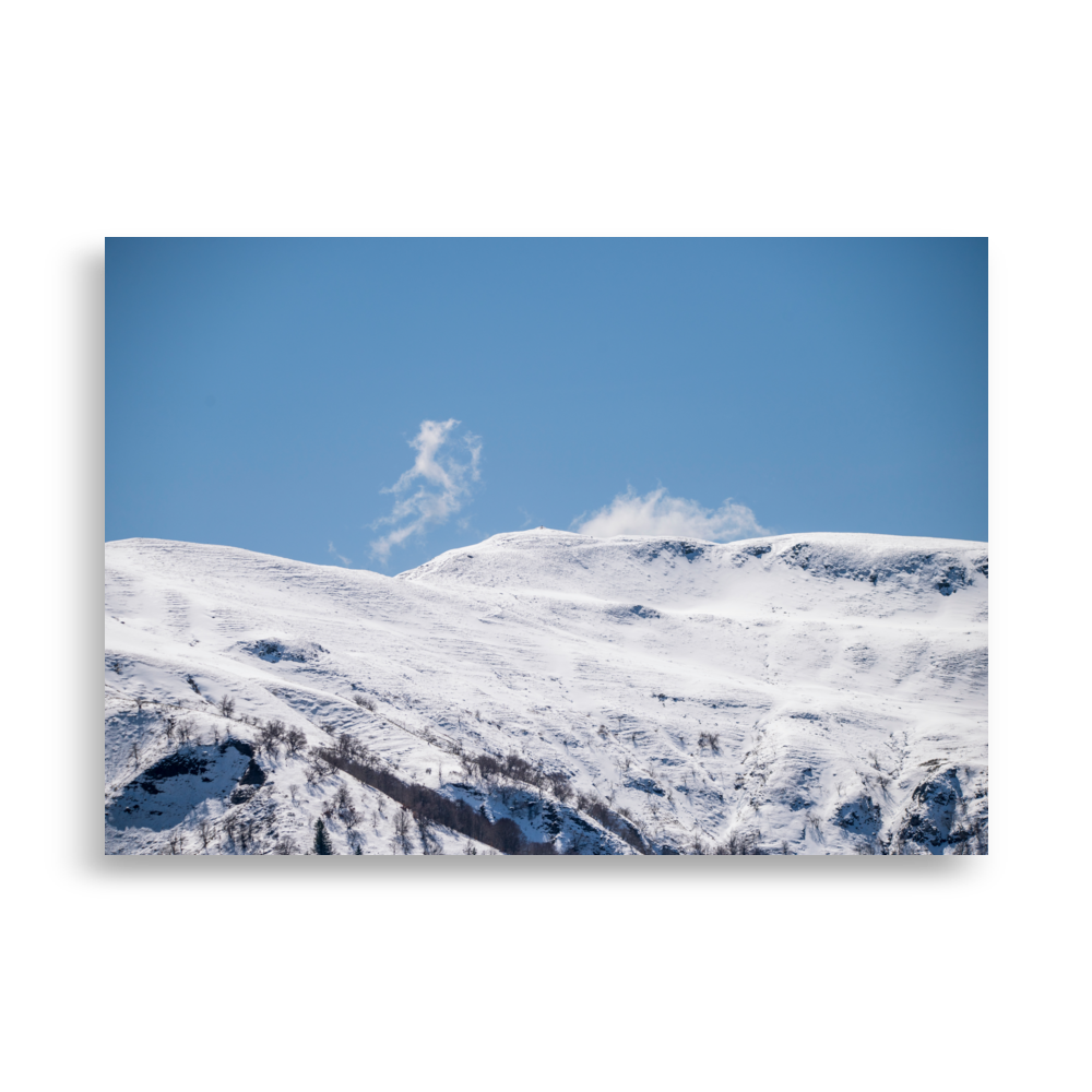 Photographie des montagnes enneigées du Cantal avec un nuage en forme de petit monstre.