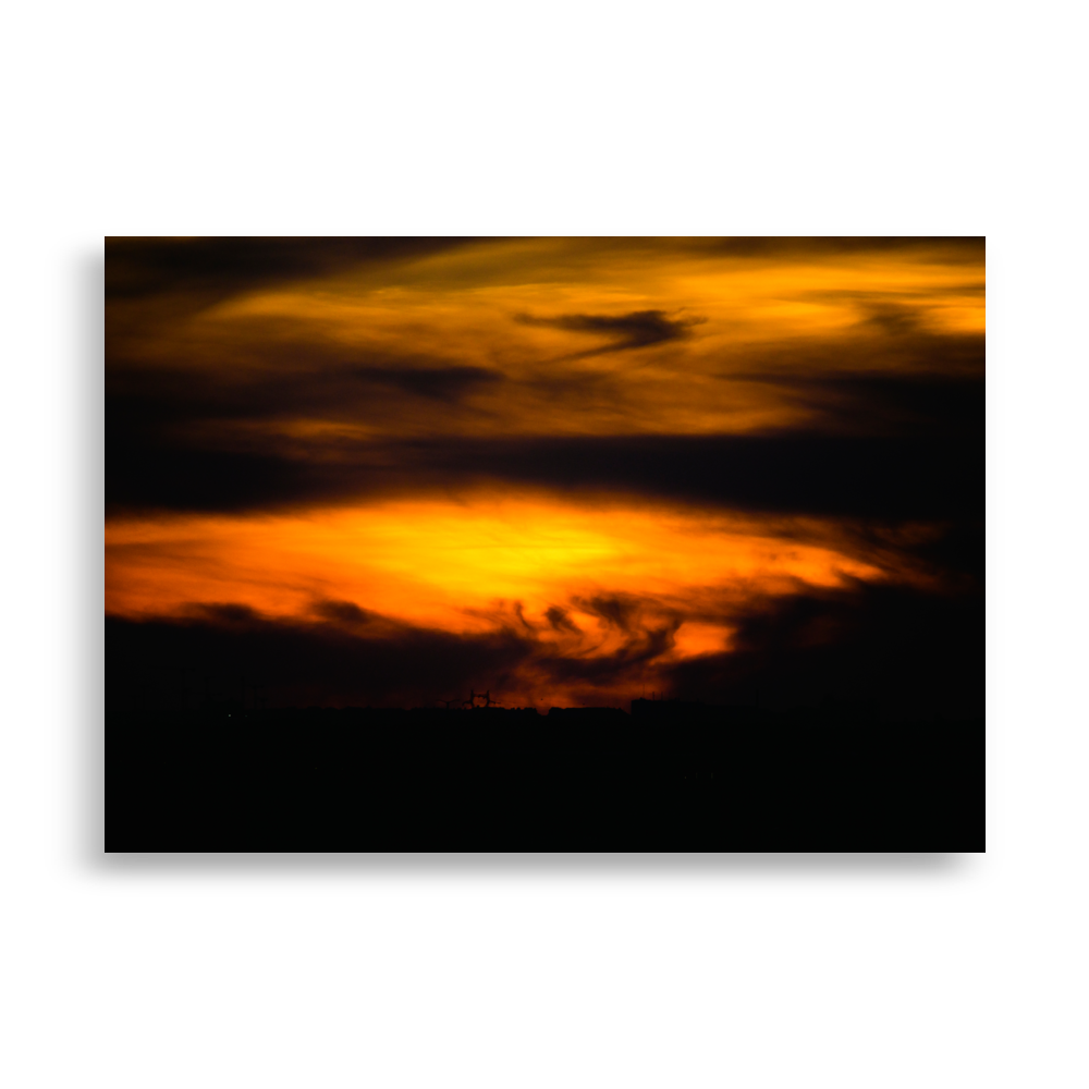 Coucher de soleil mêlé à des nuages très sombres, créant une impression de tempête dans le ciel.