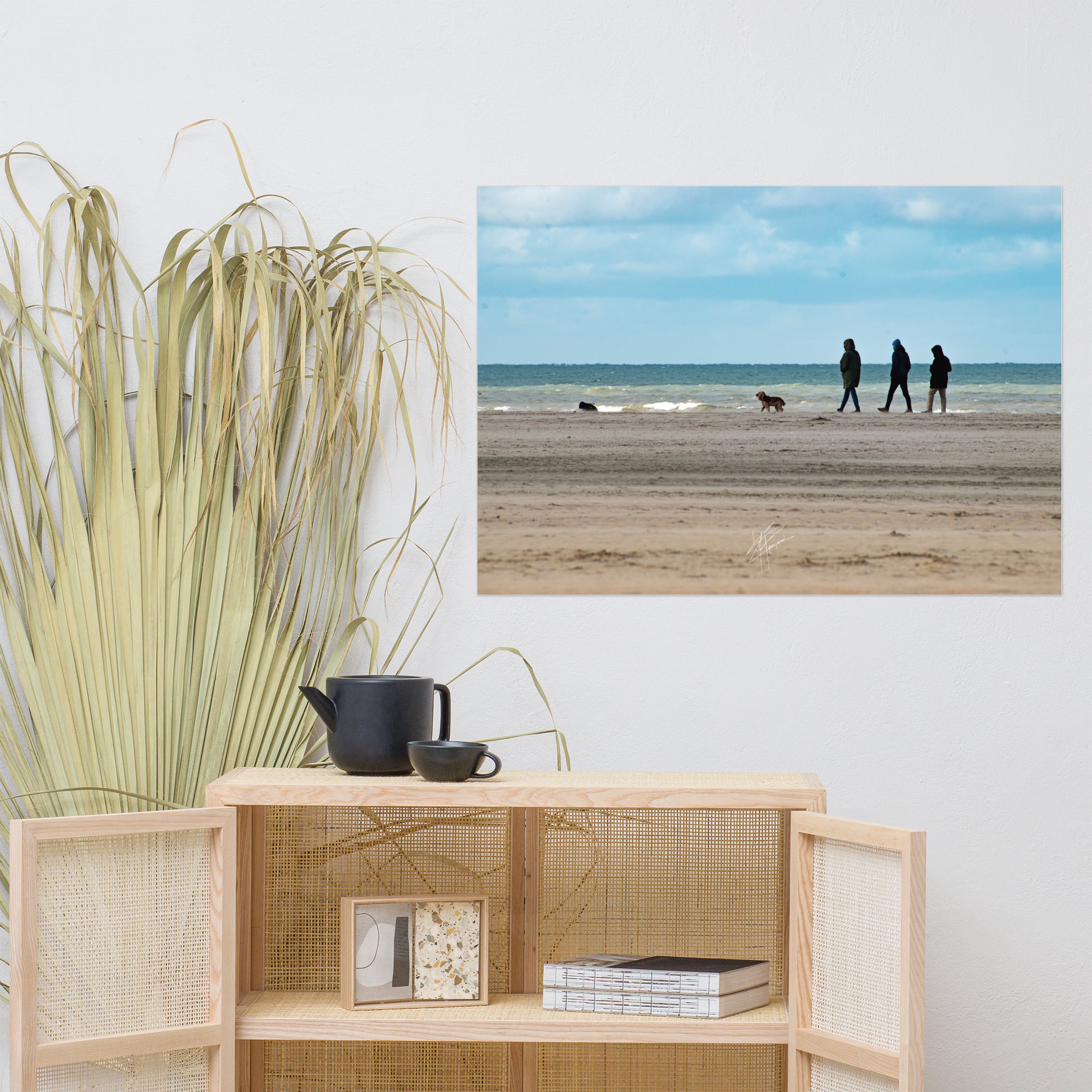 Photographie de la plage de Deauville avec des promeneurs et leur chien, capturant l'atmosphère tranquille et l'immensité de la mer normande.