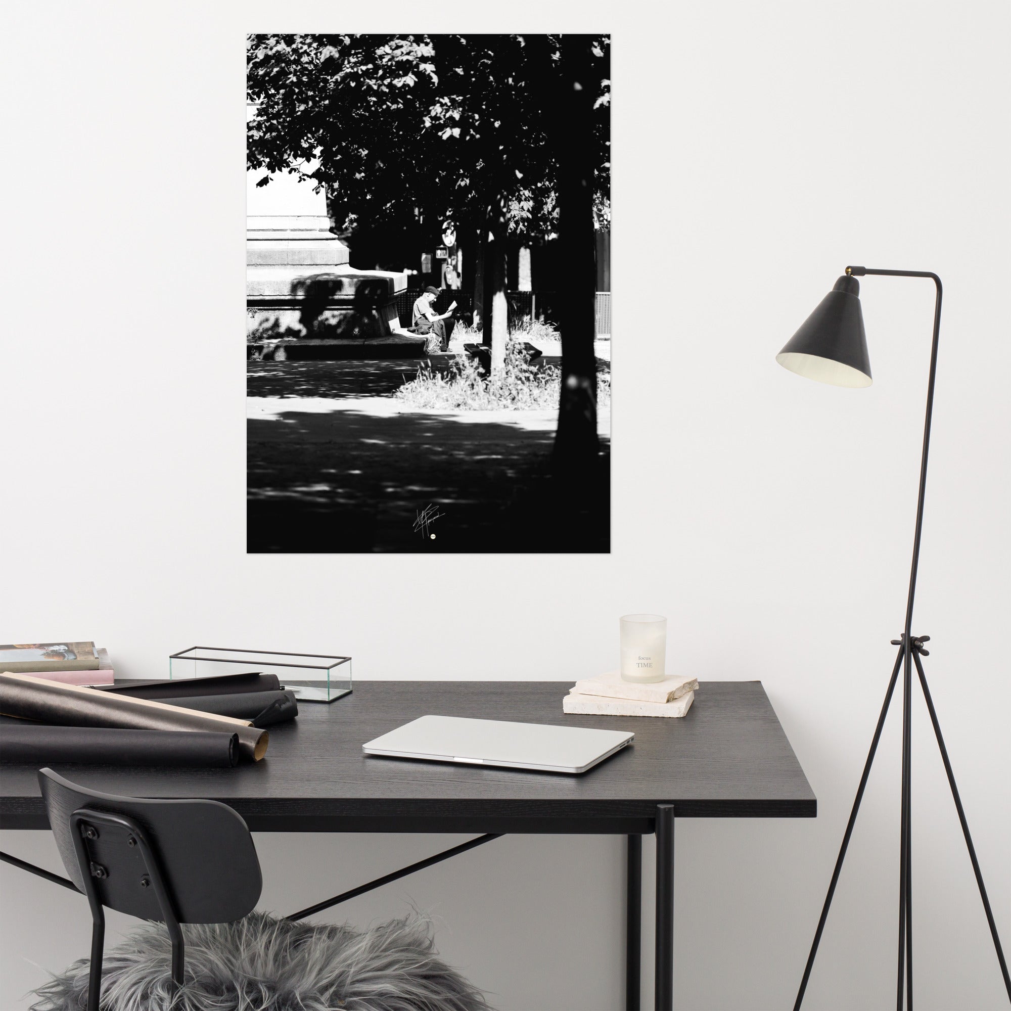 Poster photographique 'L'heure de lire', capturant un homme lisant un livre à Paris, en noir et blanc.