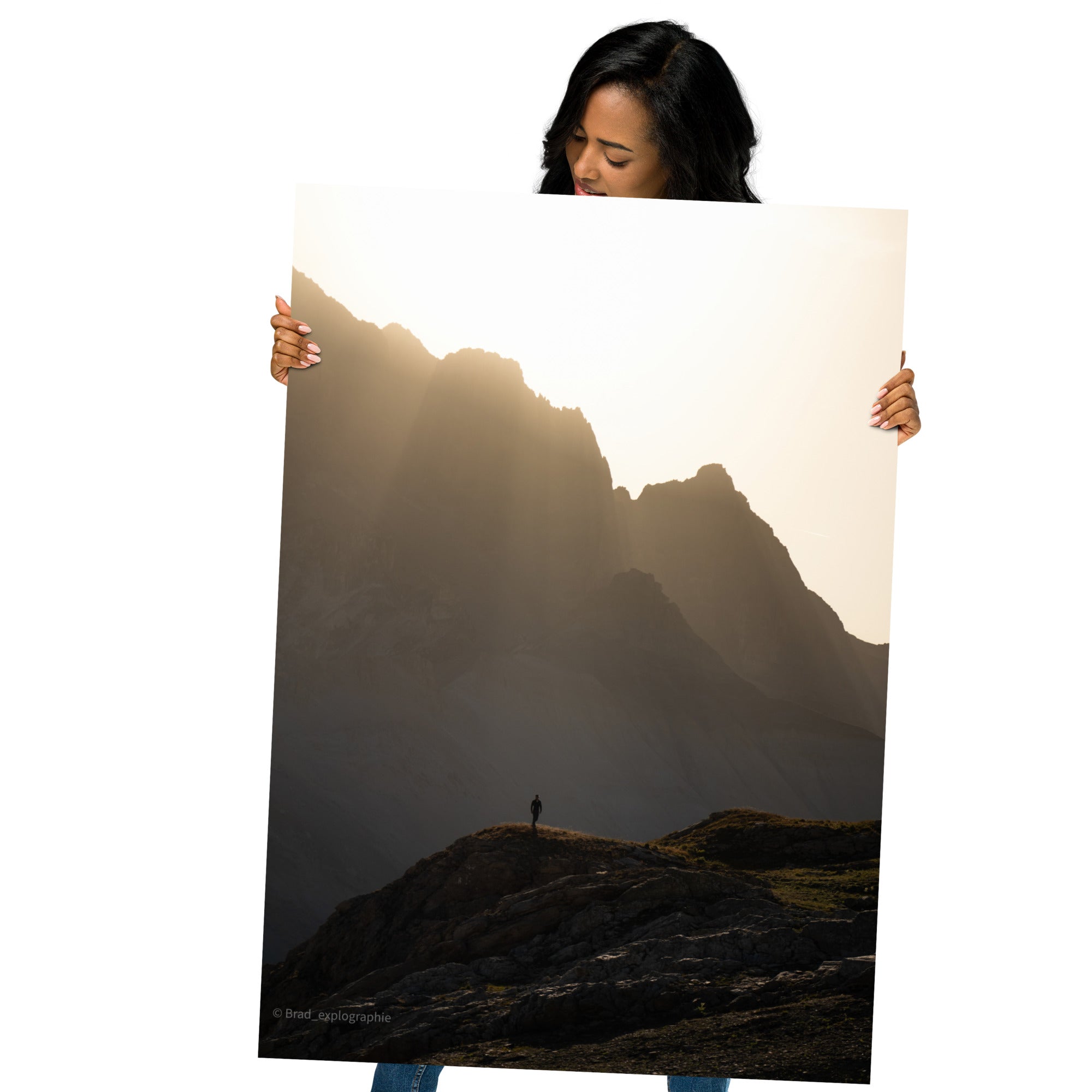 Vue panoramique des montagnes au coucher du soleil, où la lumière dorée enveloppe les pics et les vallées – une œuvre signée par Brad_explographie.