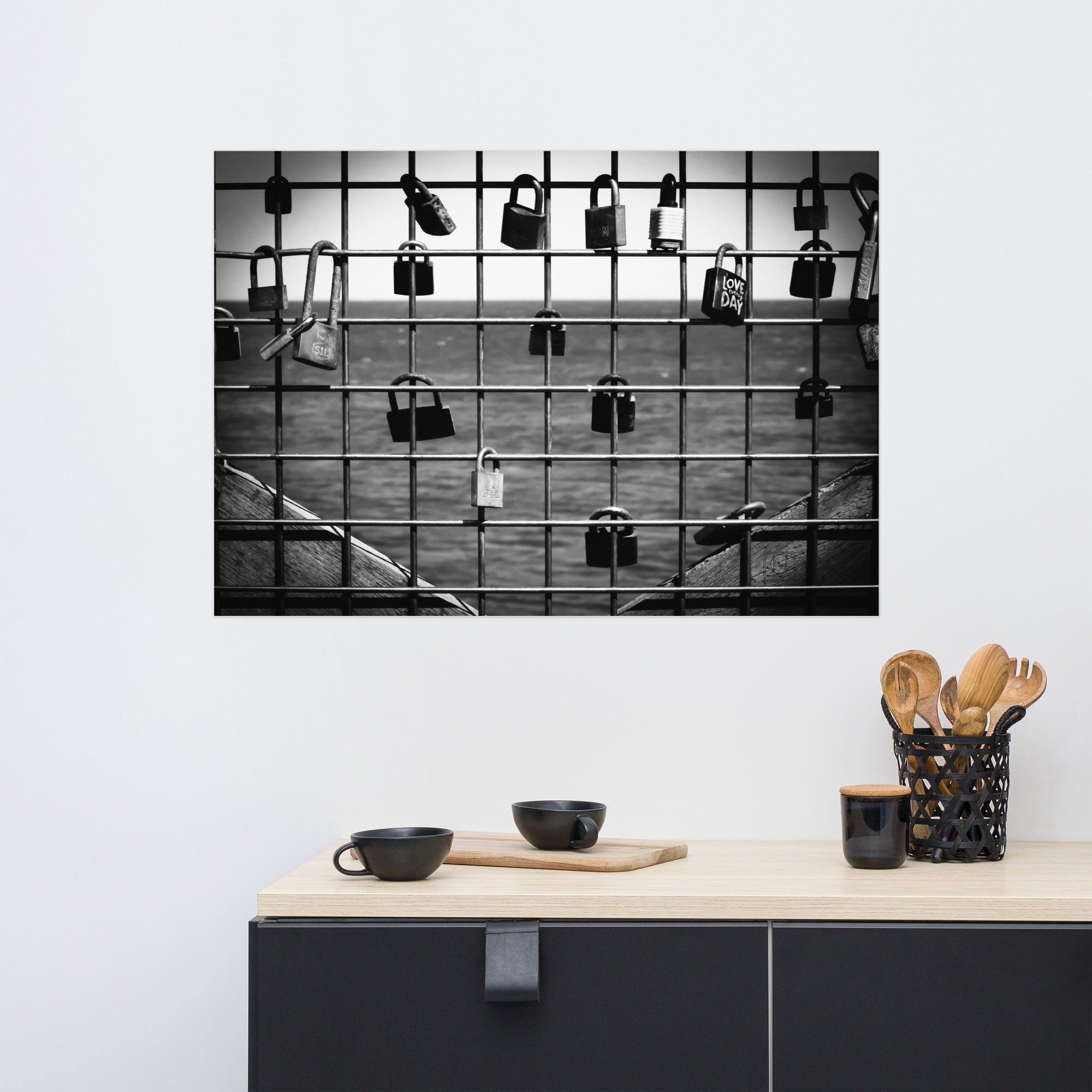 Poster 'L'accroche Cœurs' montrant des cadenas accrochés symbolisant des vœux d'amour avec la mer tranquille en arrière-plan, photographié par Hadrien Geraci. Un choix artistique idéal pour ajouter une touche romantique et d'espoir à votre intérieur.