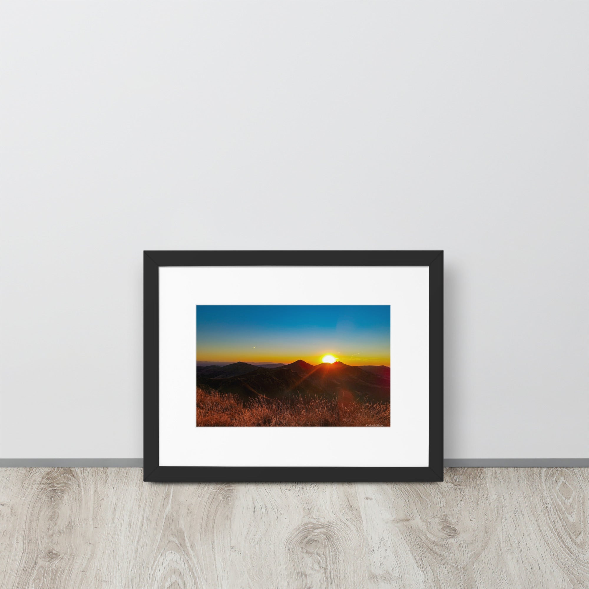 Poster encadré 'Coucher d'été' montrant un paysage montagneux du Cantal au coucher du soleil, avec des sommets silhouettés sous un ciel rougeoyant, signé par Math Shoot Fr.