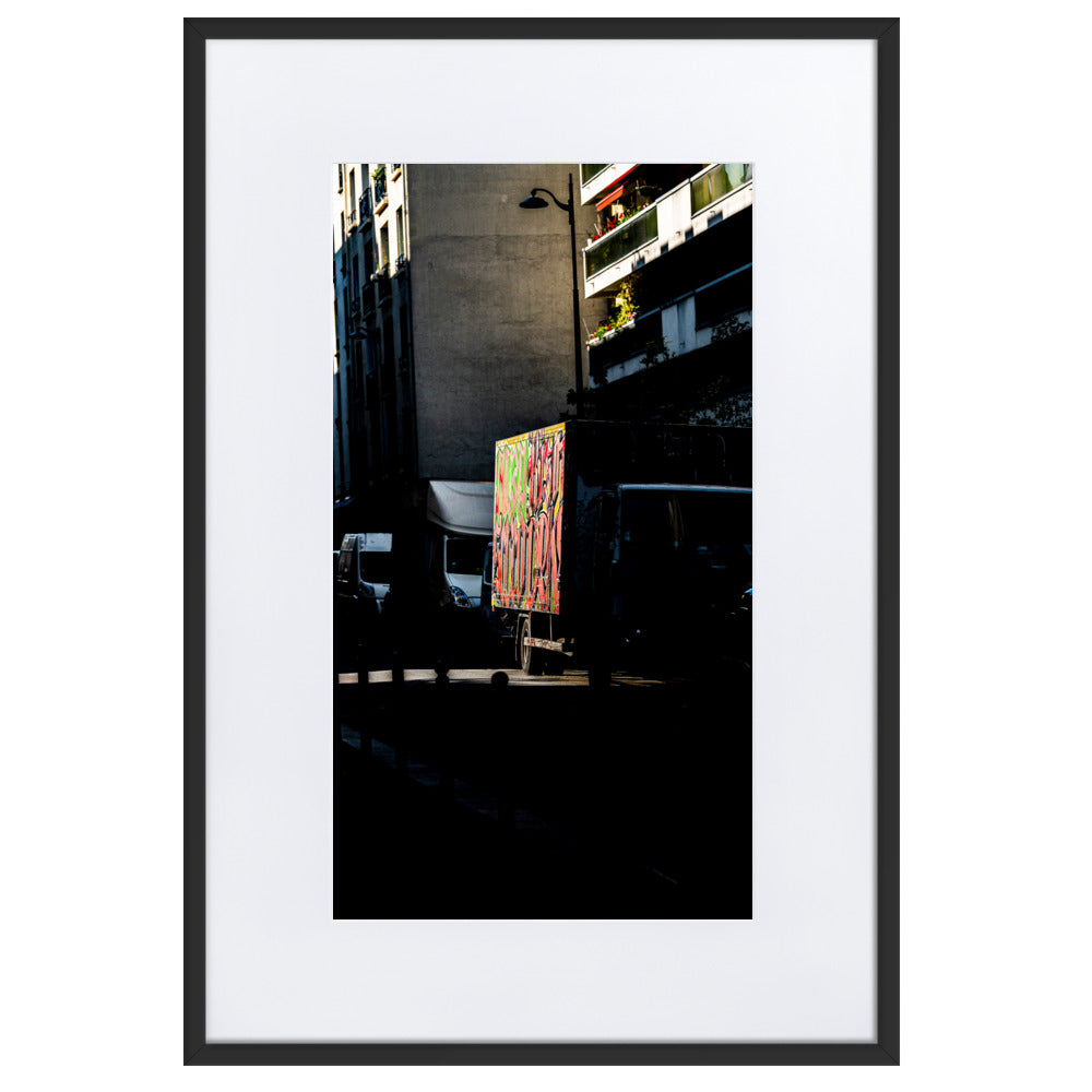 Poster La brèche - Une photographie abstraite d'un camion stationné dans une rue sombre de Paris, éclairé par un rayon de soleil.