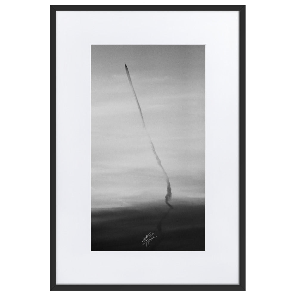 Photographie en noir et blanc du ciel avec des traces d'avions formant une longue ligne noire, encadrée d'un cadre en bois d'ayous blanc.