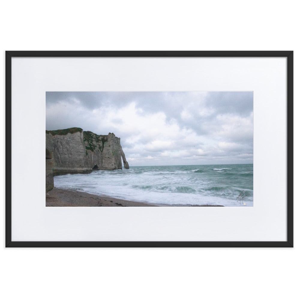 Photographie des falaises majestueuses d'Étretat, avec l'océan étendu et les vagues déferlantes, évoquant une harmonie paisible entre la terre et la mer.